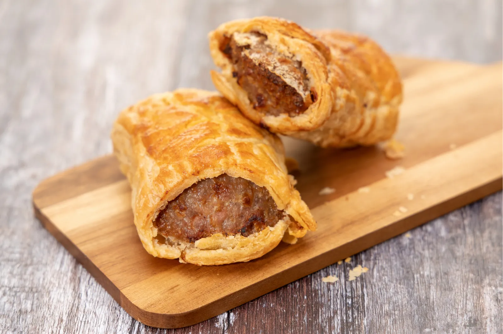 Golden homemade sausage rolls on a wooden board