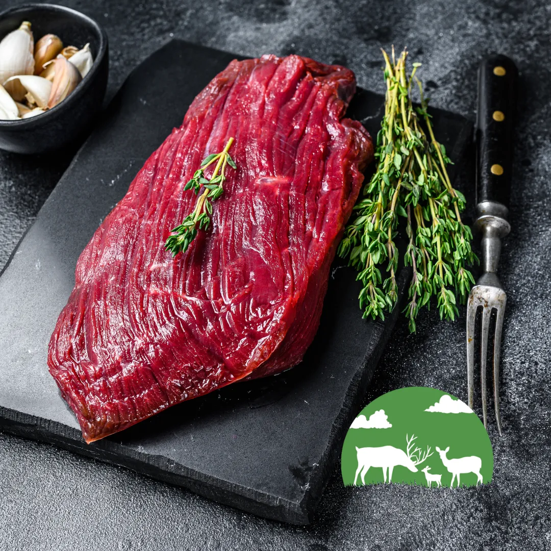 Venison steaks on a slate board with rosemary